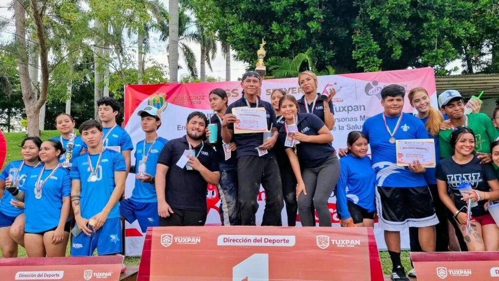 Estudiantes con medallas en el podio número 1 de la Dirección del Deporte durante el rally en Tuxpan.
