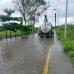 Camión con equipo Vactor y personal de Agua y Saneamiento realizando trabajos de desazolve en una calle inundada de Tuxpan.